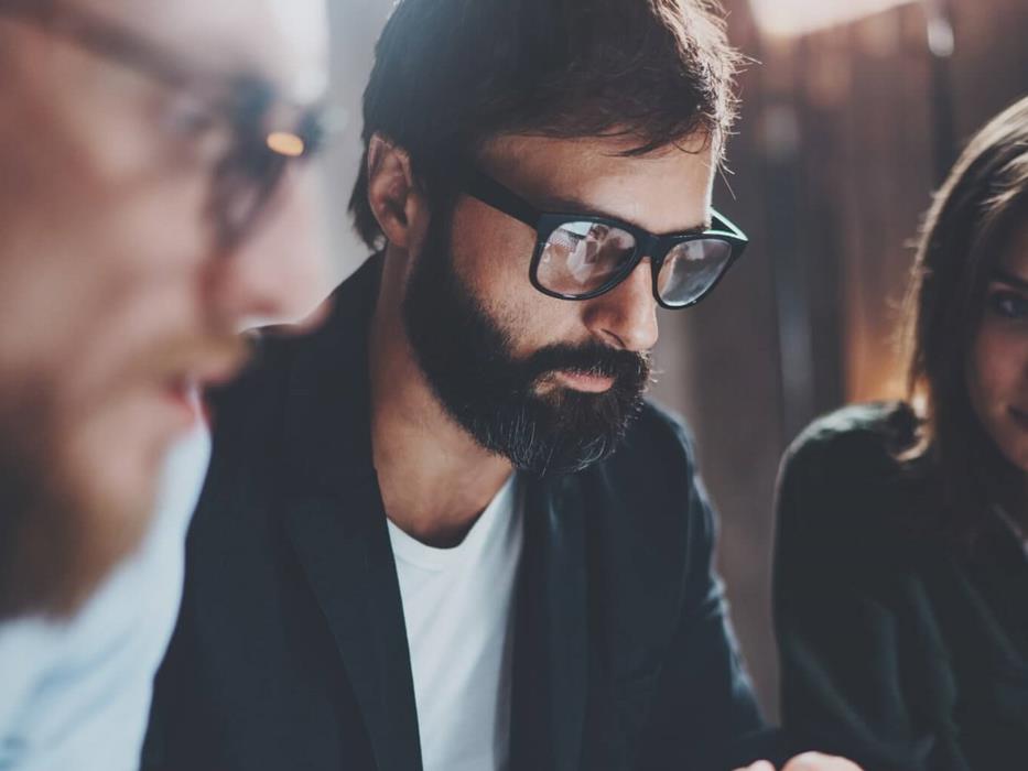 3 people looking at a screen